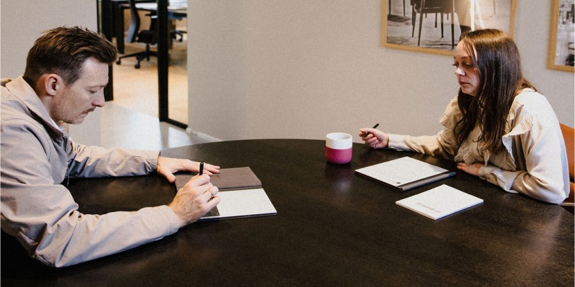 Two colleagues going through documents at a meeting table